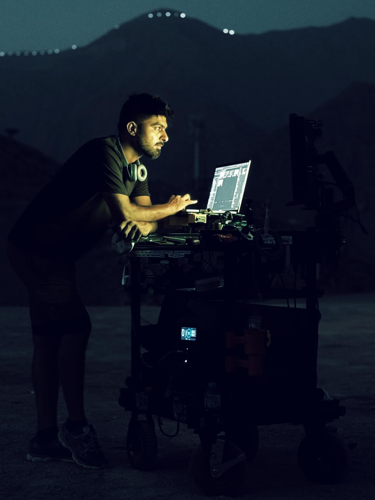Umair at the laptop on his cart at night in the mountains
